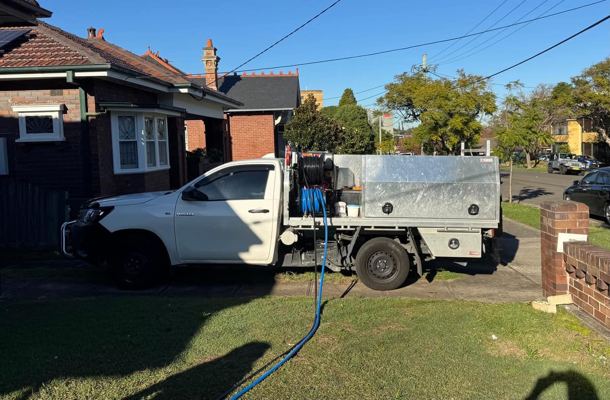 Just Pro Plumbing service ute fitted out with hose reels, gas bottles and tool storage, parked outside a residential job
